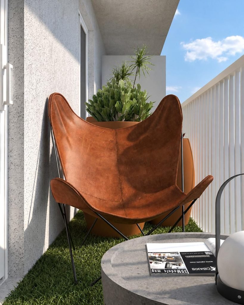 Balcon aménagé avec un fauteuil papillon brun et des plantes vertes.