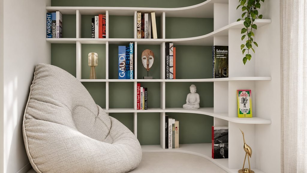 Détail du coin lecture avec fauteuil enveloppant et bibliothèque blanche sur mesure aux étagères arrondies, sur fond vert sauge.