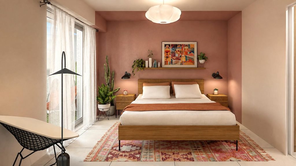 Chambre parentale aux murs rose terracotta et beige avec lit double en bois, tapis coloré et coin bureau près de la fenêtre.
