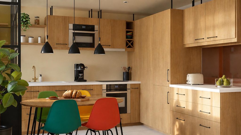 Cuisine en bois avec table de repas, chaises colorées et suspensions noires.