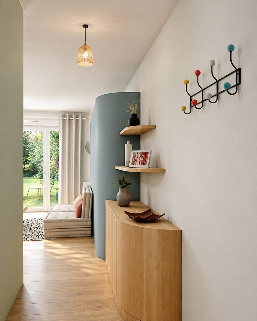Meuble d’entrée sur mesure en bois aux angles arrondis, avec rangements fermés et étagères ouvertes face au salon lumineux.
