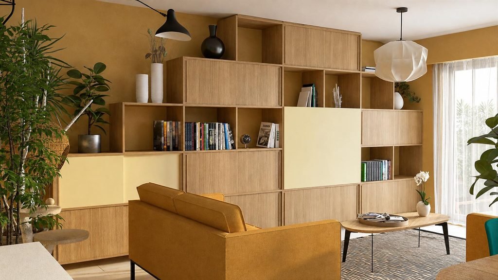 Vue du salon avec canapé ocre et grande bibliothèque en bois sur mesure.